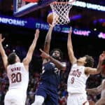 Joel Embiid #21 of the Philadelphia 76ers shoots a lay up between Georges Niang #20 and Craig Porter #9 of the Cleveland Cavaliers during the first quarter at the Wells Fargo Center on November 21, 2023 in Philadelphia, Pennsylvania.