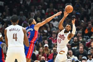 CLEVELAND, OHIO - OCTOBER 25: Donovan Mitchell #45 passes to Evan Mobley #4 of the Cleveland Cavaliers while under pressure from Cade Cunningham #2 of the Detroit Pistons during the second quarter at Rocket Mortgage Fieldhouse on October 25, 2024 in Cleveland, Ohio.