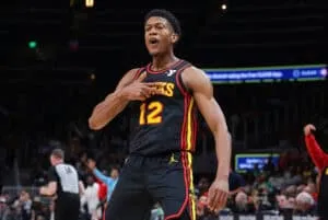ATLANTA, GEORGIA - MARCH 28: De'Andre Hunter #12 of the Atlanta Hawks reacts after hitting a three-point basket against the Boston Celtics during third quarter at State Farm Arena on March 28, 2024 in Atlanta, Georgia.