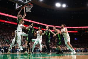 BOSTON, MASSACHUSETTS - FEBRUARY 28: Luke Kornet #40 of the Boston Celtics grabs a rebound over Sam Merrill #5 of the Cleveland Cavaliers during the second half at TD Garden on February 28, 2025 in Boston, Massachusetts. The Cavaliers defeat the Celtics 123-116.