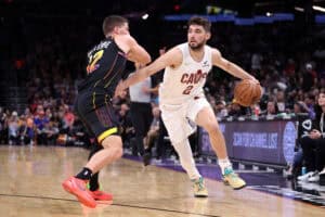 PHOENIX, ARIZONA - MARCH 21: Ty Jerome #2 of the Cleveland Cavaliers dribbles the ball against Collin Gillespie #12 of the Phoenix Suns during the second half at PHX Arena on March 21, 2025 in Phoenix, Arizona.