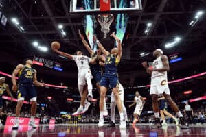 CLEVELAND, OHIO - APRIL 13: Craig Porter Jr. #9 of the Cleveland Cavaliers shoots over Tony Bradley #13 and Enrique Freeman #8 of the Indiana Pacers during overtime at Rocket Arena on April 13, 2025 in Cleveland, Ohio. The Pacers defeated the Cavaliers 126-118 in double overtime.